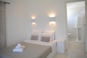 a white bedroom with a bed with a teddy bear on it at Maistrali in Provatas