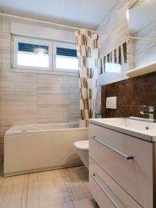 y baño con bañera, aseo y lavamanos. en Veduta Luxury Apartments, en Split