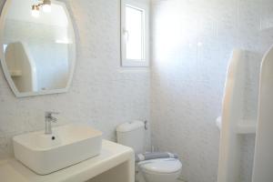 a white bathroom with a sink and a toilet at Maistrali in Provatas