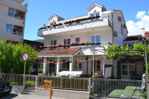 a white house with flowers on the balcony at Villa Merci Budva in Budva