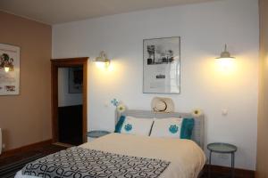 a bedroom with a bed and two stools at Maison de Maitre I in Availles-Limouzine