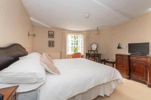 a bedroom with a white bed and a television at Royal Glen Hotel in Sidmouth