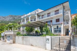 an apartment building with a fence in front of it at Apartmani Zara & Maris in Gradac