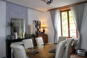 a dining room with a wooden table and white chairs at Maison de Maitre I in Availles-Limouzine