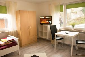 Habitación pequeña con escritorio y TV. en Unterkunft4You, en Usingen
