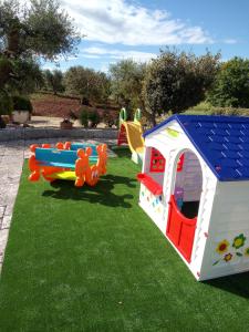 une maison de jeux pour enfants et des équipements de jeux sur l'herbe dans l'établissement Trulli dell'aia, à Alberobello