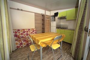 a small kitchen with a wooden table and chairs at Camping Dal Pino in Marina di Massa