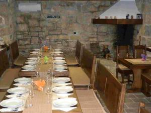 una mesa larga con platos y vasos. en Agroturism Stara Štala, en Borut