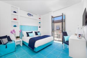 ein blau-weißes Schlafzimmer mit einem Bett und einem Stuhl in der Unterkunft Sersale Suites in Sorrent