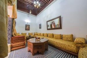 sala de estar con sofá y mesa en Riad L'Artiste, en Fez
