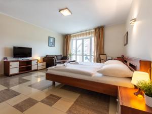 ein großes Schlafzimmer mit einem großen Bett und einem TV in der Unterkunft VacationClub – Avangard Resort Apartament 23 in Świnoujście