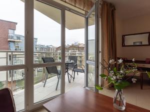 sala de estar con una puerta de cristal que da a un balcón en VacationClub – Avangard Resort Apartament 23 en Świnoujście