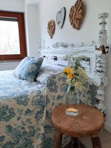 una camera da letto con un letto e un vaso di fiori su un tavolo di B&B dei Laghi a Magreglio