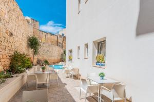 a patio with tables and chairs and a pool at Palazzo Violetta in Sliema +37 photos