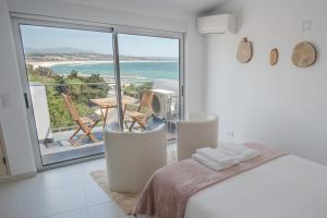 a bedroom with a bed and a view of the ocean at Apartamentos Pinhão in Lagos