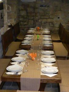 una mesa larga con platos y copas de vino. en Agroturism Stara Štala en Borut