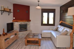 a living room with a white couch and a fireplace at La Casita Del Abuelo in Villalmanzo