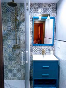 a bathroom with a blue sink and a mirror at La Casita Del Abuelo in Villalmanzo