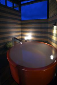 a large tub in a room with a tv at Hotel Takamatsu in Kusatsu