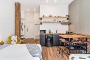 - une cuisine avec un évier et une table dans une chambre dans l'établissement INITIAL - LOFT LAMA - Centre-Ville de Québec, à Québec