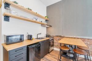 eine Küche mit einem Waschbecken und einem Holztisch in der Unterkunft INITIAL - LOFT LAMA - Centre-Ville de Québec in Québec