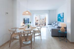 un soggiorno con tavolo, sedie e divano di Calmo Singular Apartments a Gandía