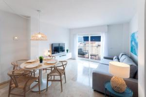 uma sala de estar com uma mesa e um sofá em Calmo Singular Apartments em Gandia