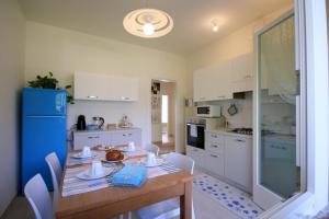 a kitchen with a table and chairs and a blue refrigerator at La Casa di Eva in Vittorio Veneto