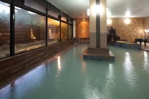 
a large swimming pool in a large building at Hotel Takamatsu in Kusatsu
