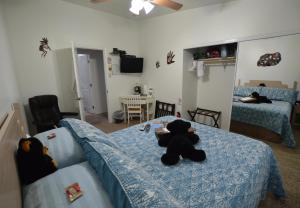a teddy bear laying on a bed in a bedroom at The Bear's Den B&B in Page