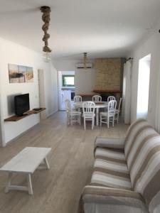 a living room with a couch and a table and chairs at Casa Can Joan Guasch in Sant Francesc Xavier