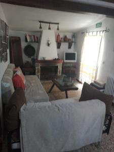 uma sala de estar com um sofá e uma mesa em Casa rural El Rincón em Padiernos