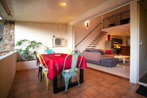 a dining room with a red table and chairs at Vue Lagon et MOOREA in Taapuna