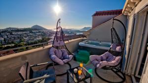 a balcony with chairs and a swimming pool on a building at Dubrovnik Icy Guest House in Dubrovnik