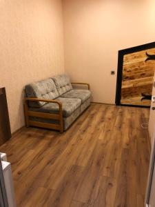 a living room with a couch and a wooden floor at Apartment Zaziashvili 30 in Tbilisi City