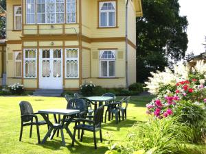 a group of tables and chairs in front of a house at Guesthouse Airava in Jūrmala
