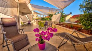 wazon z fioletowymi kwiatami na stole na patio w obiekcie Dubrovnik Icy Guest House w Dubrowniku