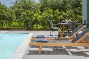 a patio with a table and chairs next to a swimming pool at Villa Lantana in Skala Kefalonias