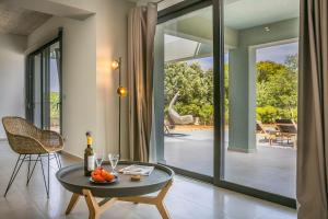 a living room with a table and a glass door at Villa Lantana in Skala Kefalonias