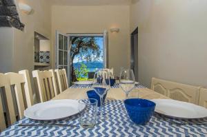 una mesa con platos y copas de vino. en VILLA CASTELLo PORTOVENERE, en Portovenere