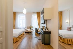 a hotel room with two beds and a desk at Vilnius Apartments in Vilnius