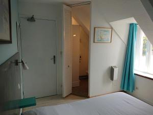 - une chambre avec un lit et une porte avec une fenêtre dans l'établissement Auberge l'Air de Vent, à Fréhel