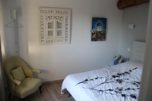 sypialnia z łóżkiem i krzesłem w obiekcie LA FERME DE CAPUCINE w mieście Culhat