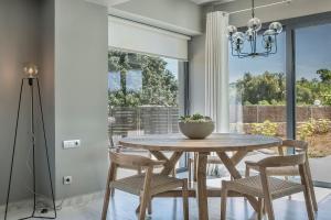 a dining room with a wooden table and chairs at Villa Begonia in Skala