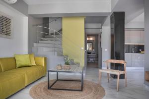 a living room with a yellow couch and a table at Villa Begonia in Skala