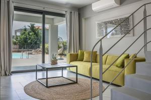 a living room with a yellow couch and a table at Villa Begonia in Skala