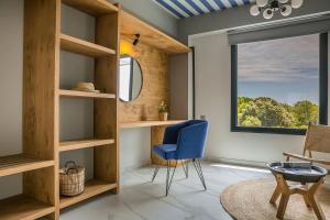 a living room with a blue chair and a window at Villa Begonia in Skala +17 photos