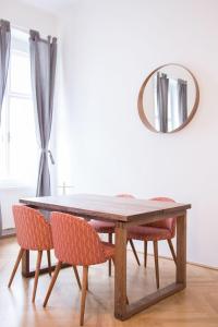 a dining room table with chairs and a mirror at HeyMi Apartments Stephansdom in Vienna