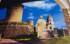 una estatua de un hombre frente a un castillo en Gesualdo da Venosa en Venosa