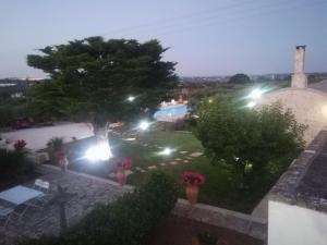 a garden at night with a tree and lights at Trulli Dal Conte in Locorotondo